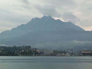 Looking across part of Lake Luzern at a high mountain in the distance on a cloudy day