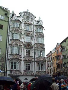A five-story blue building with three large balconies on each floor and rococo decorations