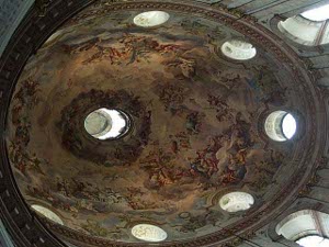 The dome is punctured by 8 circular windows and a circular hole at the top; the remainder is frescoed in a rose pink mural of rococo beauty
