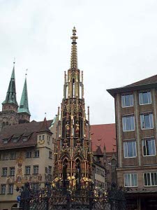The fountain is built like a church spire, with gradually smaller diameter tiers, decked out in gold and shiny sculptures, coming to a narrow spike perhaps 30 feet high.