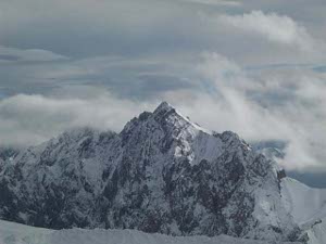 A craggy Alpine peak, with a hint of sunshine, half rocks and half snow, but below the level of the Zugspitze