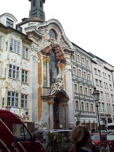The church exterior has immense baroque carving above the door