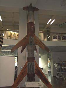 With large angled wings this rocket, perhaps two stages, stands two stories high