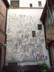 A wall was stuccoed white and painted with the dates 1189 and 1989 and a mural of scenes from Hamburg's history