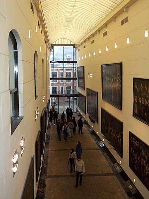 The two story walkway is protected by a translucent roof and affords the pedestrians closeup views of the large paintings of Amsterdam civic groups