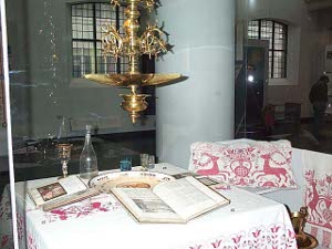 Set with white cloth trimmed in embroidered animal designs, the table features dishes and books set out