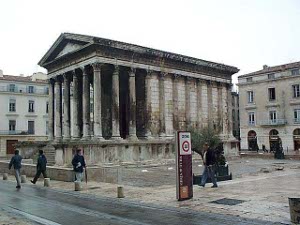 This rectangular stone building has an arched stone roof and a portico surrounded by tall columns