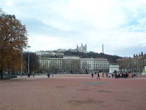 The place is enormous stretching for what would normally be five or ten blocks.  The surface is all a reddish clay or gravel.  In the distance on the hilltop is the dominant structure of the Basilica of Notre Dame de Fourviere.