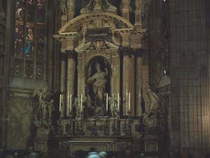 The main altar is polished marble, with pillars and candles and highly ornate, surrounded by stained glass