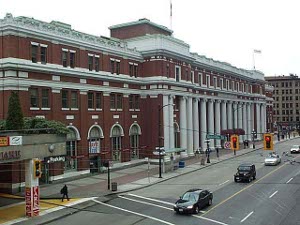 A long three-story red brick building with many white pillars in front.