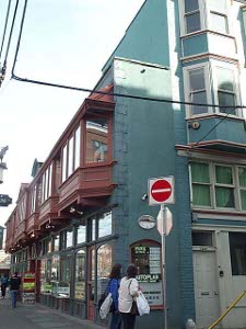 A green two-story building backing against a larger green three-story building, the narrowest building appeals to tourists and has a Believe-It-Or-Not museum on the second floor