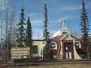 Brightly painted in yellow and brown, the Catholic Church is built out of an old quonset hut