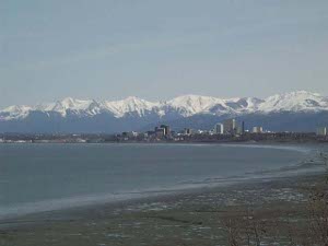 The beach curves in a graceful arc to the city of Anchorage, complete with high-rise buildings, in the distance