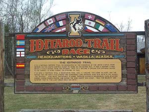 A large sign describes the race and bears flags of a number of nations whose teams have competed, including Russia, Norway, and Sweden