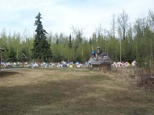The brightly colored spirit houses are about the size of dog houses over the graves