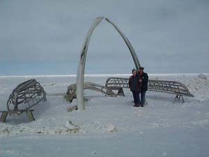 A small monument, consisting of a large arch built of whale baleen and the frames of two whaleboats, ready to be covered and used, marks the northernmost Point Barrow, where the authors are pictured.