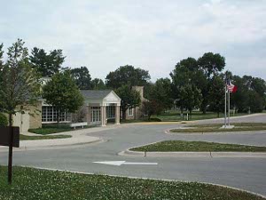 A low building of tan stone, the Hoover library sits in a large park.
