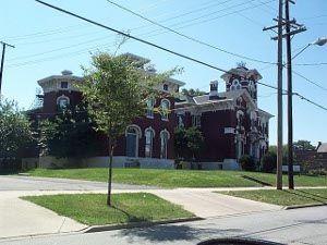 A Red brick Victorian building with many wings and towers and extensive white stone trim.