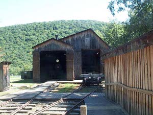 Two large old wooden sawmills have railroad tracks leading to them