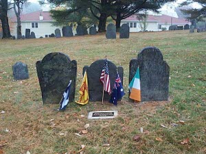 In front of three dark slate gravestones are five flags and a fresh bronze plaque, set in cement, to commemorate the early Crawfords
