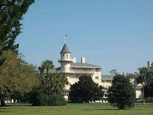 A four story white building with a tower and galleries, one of the larger on Jekyll Island