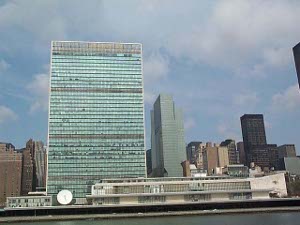 From the East River, the UN building rises with a wall of aqua-colored glass windows, intersperced by grey horizontal stripes where the windows are not so colored