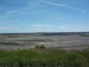 From the grassy hilltop field in the foreground to the distant Lake Huron, the quarry stretches miles ahead, to the right and left (disappearing off the sides of the photo), and deep into the earth.