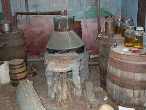 Several barrels and a stone and copper still, fired by wood, make an exhibit of moonshining in Hugo, Oklahoma