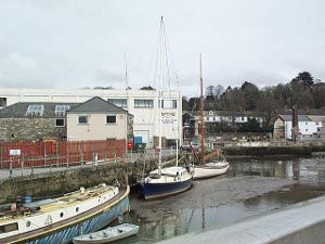 With sides built up in stone walls, the Truro River at low tide seems a mud flat, but the boats remain upright, in pools of water