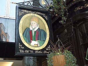 The pub sign is a painting of a Cambridge-educated doctor, with a green robe, white collar, and orange hat.