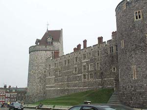 The photo depicts two towers of Windsor Castle and the connecting wall, the whole stone edifice some six stories high (including subterranean levels) and crenellated for defense