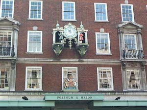 Above the copper-green entrance to Fortnum & Mason, mounted on the wall on the third story (the second story displays the royal arms) is the famous mechanical clock