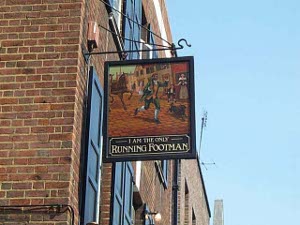 The photo shows just the pub sign, of a liveried footman running ahead of a horse on a bricked street
