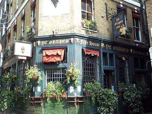 The Grpaes is painted a dark green with red awnings and gold trim, the walls covered with window boxes filled with greenery