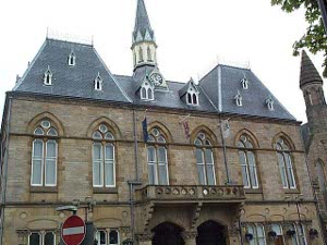 The Bishop Auckland Town Hall has high mansard slate roof with two levels of dormer windows and a central steeple