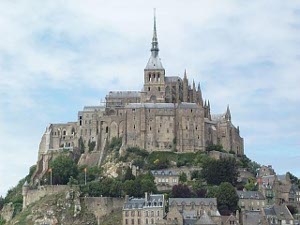 A photogenic sight, Mont St. Michel is built on a rocky outcropping on a flat Normandy beach.  The spire on top dominates the view