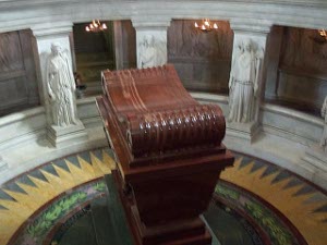 Carved out of a gleaming brown wood, the enormous tomb rises on a pedestal surmounted by a scrollwork.  The pedestal in turn sits in a circular chamber (below the viewing balcony) with an elaborately tiled floor and marble statues all around.