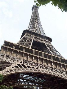 From the ground, the metal lattice work of the Eiffel Tower stretches up in a graceful slender curve to the narrow top