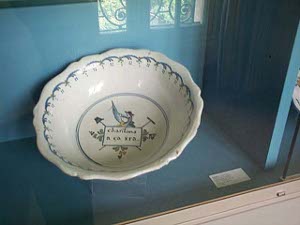 Ah! ca ira, meaning oh, it'll be fine, was an emblematic song of the French Revolution, first heard in May 1790.  In this photo the slogan is depicted at the bottom of a white and blue pottery bowl