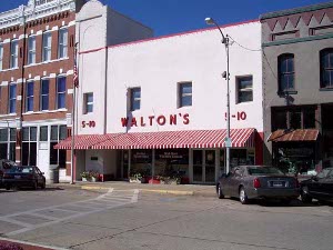 A small plain building labelled Walton's 5-10 with a red and white striped awning in front was Sam Walton's original store.