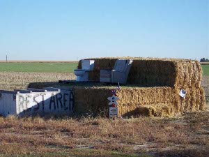 On top of hay bales sit a commode and an easy chair