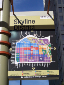 A map of downtown Houston, showing districts in different colors, is bolted to a street pole