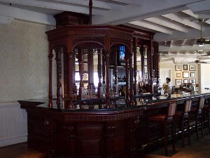 The dark mahogany wood of the bar is reflected in the matching cabinet for glasses and bottles in the lobby of the Hotel del Coronado