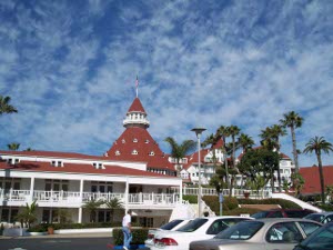 Taken from the parking lot, this photo against a blue sky well powdered with gauzy clouds shows part of the Hotel del Coronado, with its white woodwork and red roofs