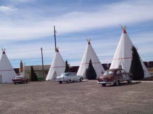Three wigwams are shown, each with a 1940s or 1950s classic car parked in front