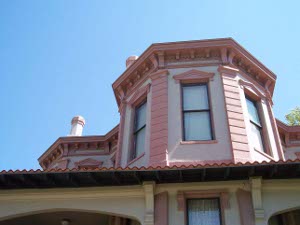 Looking up from the ground one can see three octagonal wings of the Ace of Clubs House, with ornate coral-colored carpenter-gothic wood trim and pale peach background.