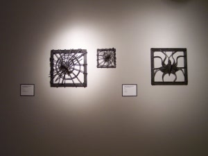 Spiders sculpted out of black iron form appealing silhouettes against a brightly lit white wall in the National Ornamental Metal Museum, Memphis.