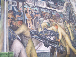 The Diego Rivera fresco depicts workers building an automobile chassis on an assembly line.