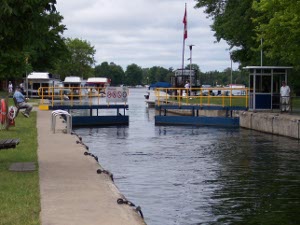 The blue lock gates are just closing; houseboats are lined up for rent.