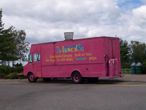 A food service truck featuring Fresh Cut Fries, painted bright pink